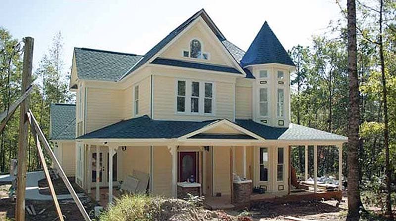 House plan exterior: Two-story Victorian home with wrap-around porch, corner turret, and front gable.
