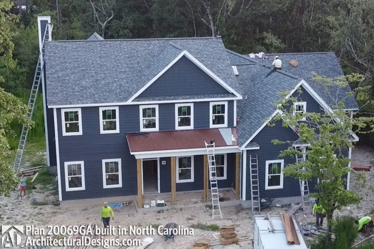 House plan exterior: Two-story Modern Farmhouse with dormers, gables, and a metal porch roof.