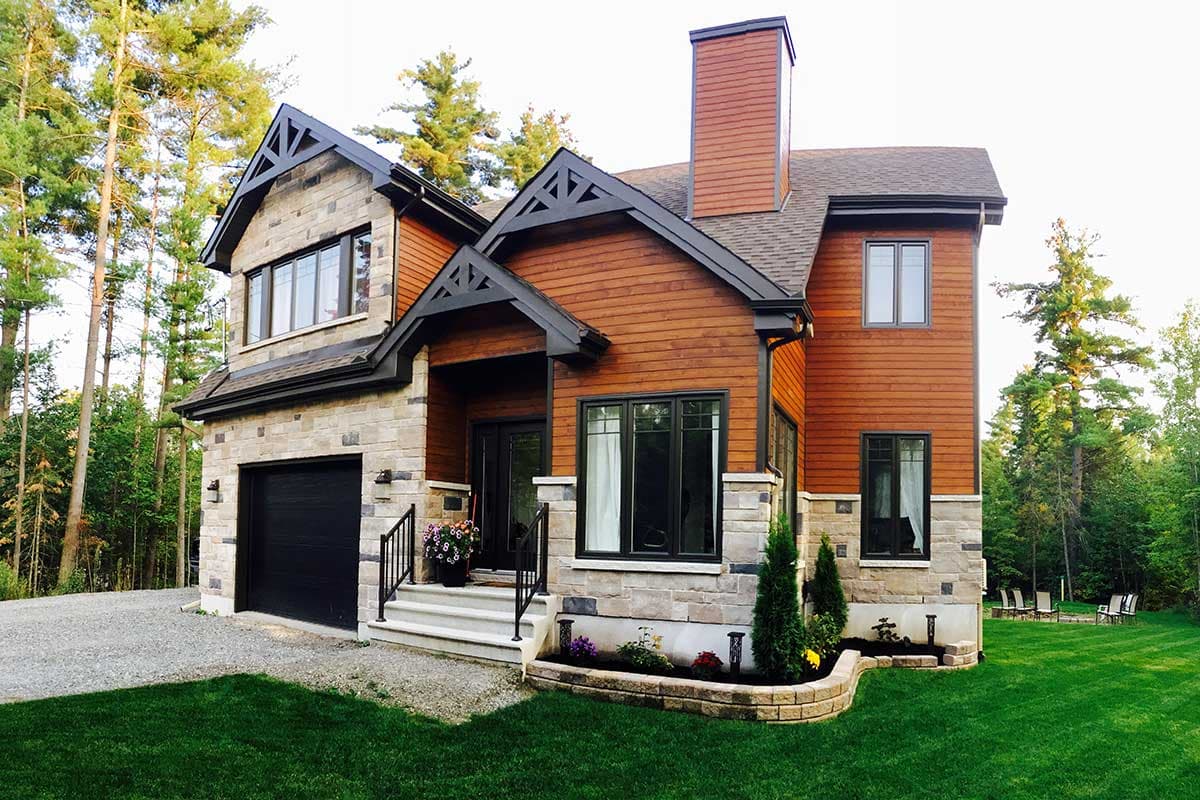 House plan exterior: Two-story modern home with stone and wood siding, prominent gables, and a tall brick chimney.