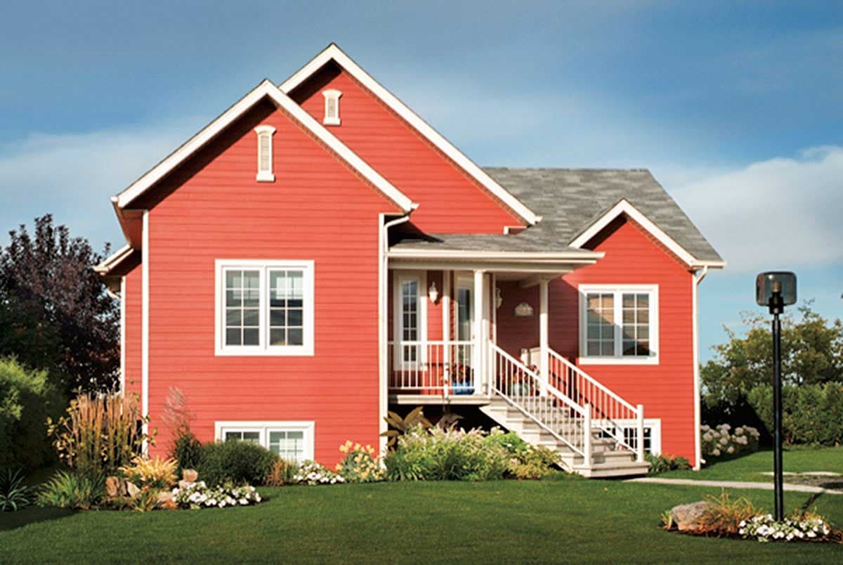 House plan exterior: Two-story red house with prominent gables, white-trimmed windows, and a covered front porch with stairs.