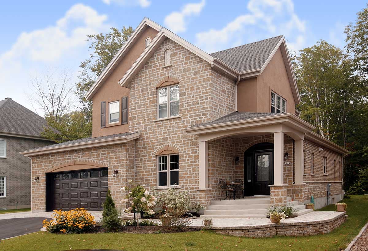 Two-story house plan exterior with stone facade, covered porch, arched entryway, and attached garage with arched door.