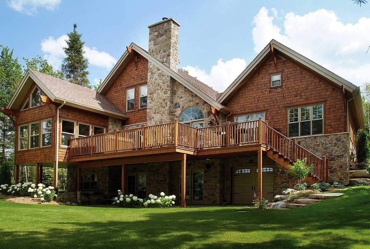 House plan exterior with cedar shake siding, stone accents, multi-level deck, and attached garage.