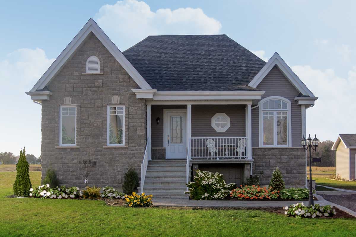 House plan exterior: Two-story home with stone and siding, gabled roof, central porch with white railing, and arched window.