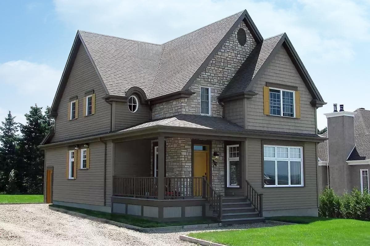 House plan exterior with stone accents, prominent gables, a covered porch, and multiple dormers.
