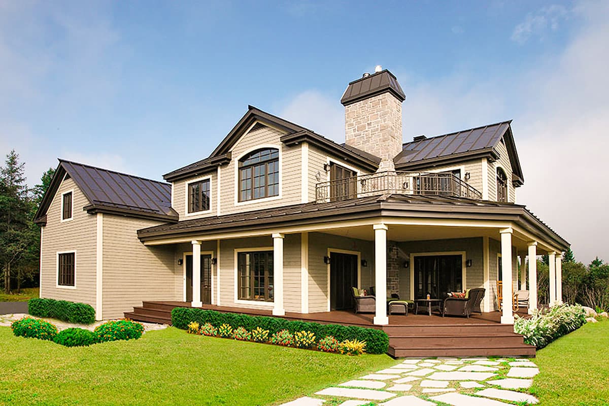 House plan exterior: Two-story home with stone chimney, wraparound porch, gables, and arched window.
