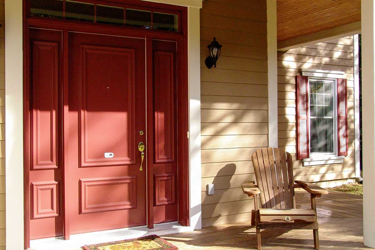 House plan exterior: Modern Farmhouse style with a deep red paneled double door, transom window, and wood siding.