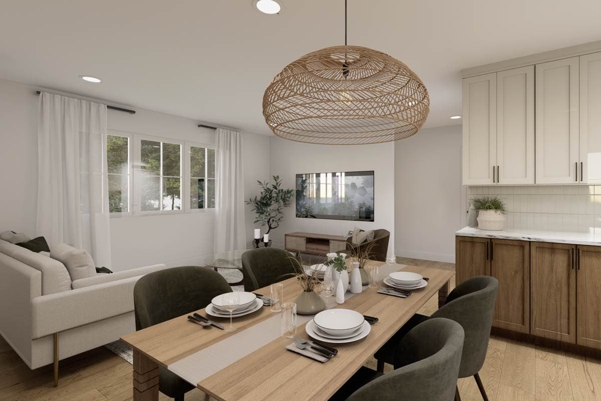Open-concept living and dining area with large windows, dining table set for six, sofa, and kitchen cabinetry.