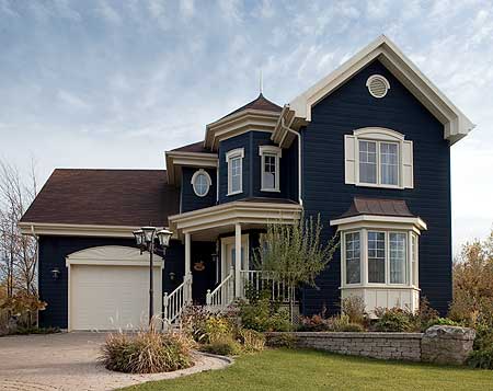 House plan exterior: Two-story dark blue home with a covered porch, bay window, dormer, and attached garage.