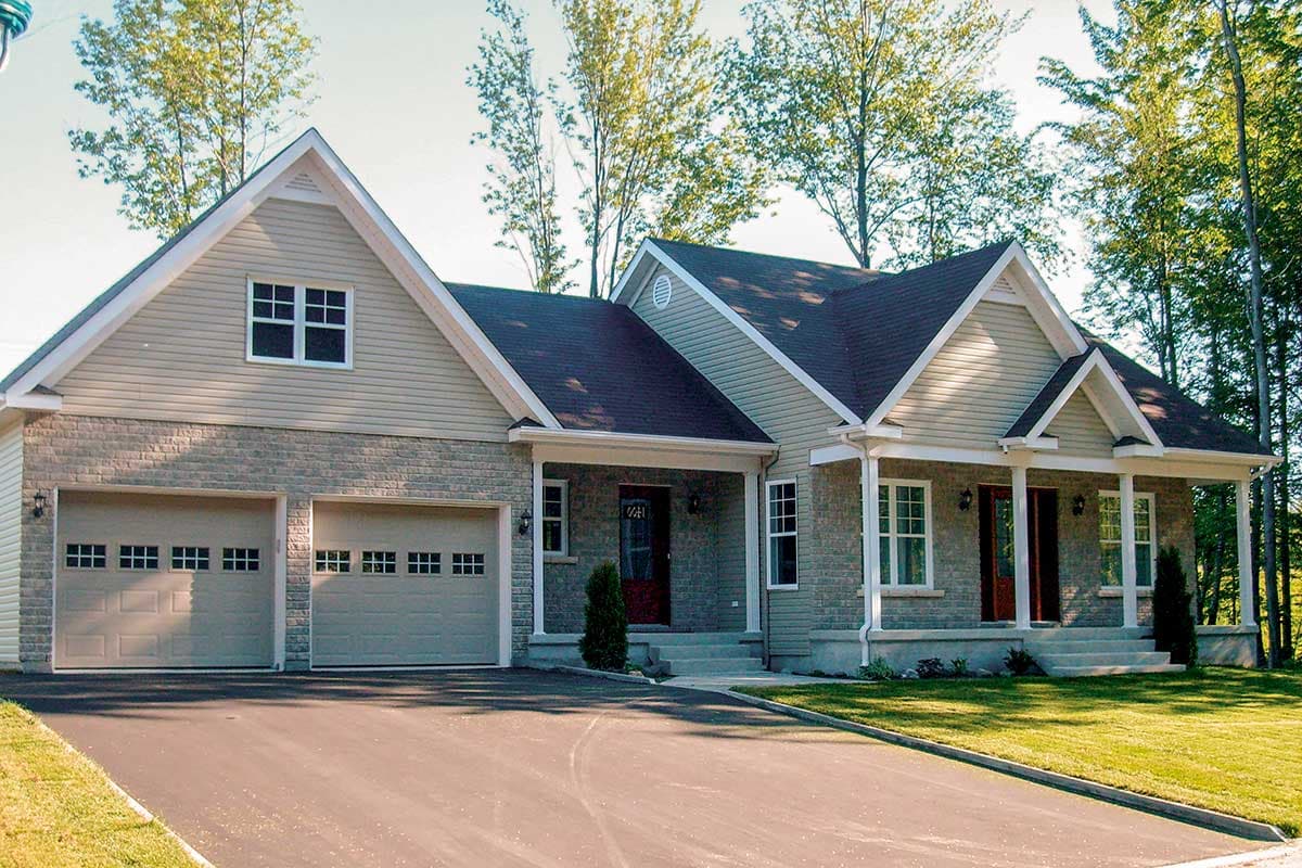House plan exterior: Gable roofline, stone and vinyl siding, a covered front porch with columns, and a two-car garage.