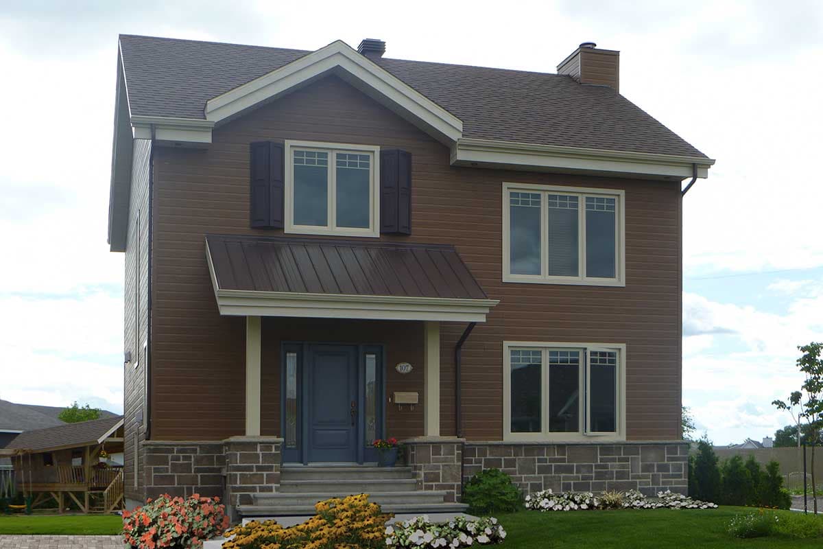 House plan exterior: Two-story home with brown siding, stone foundation, covered entry with metal roof, and multiple windows.