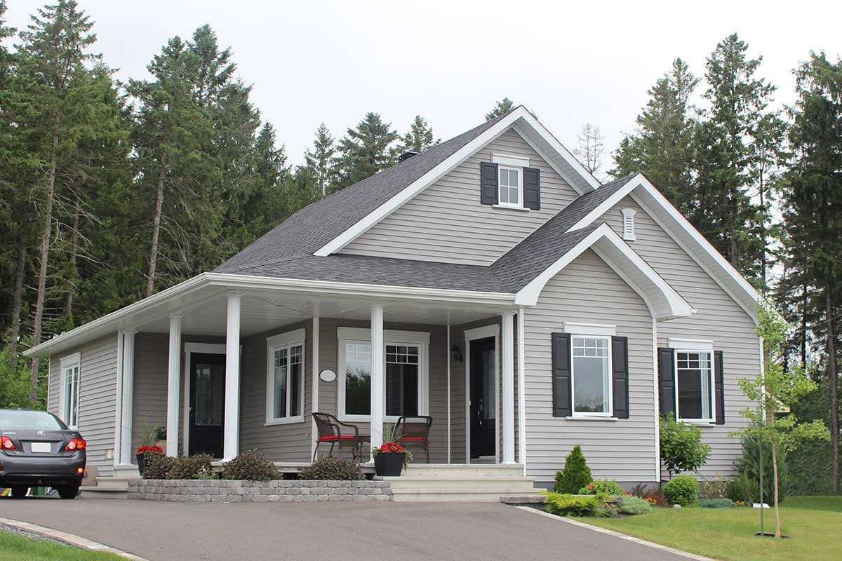 One-story house plan exterior with wrap-around porch, gables, dormer, and vinyl siding.