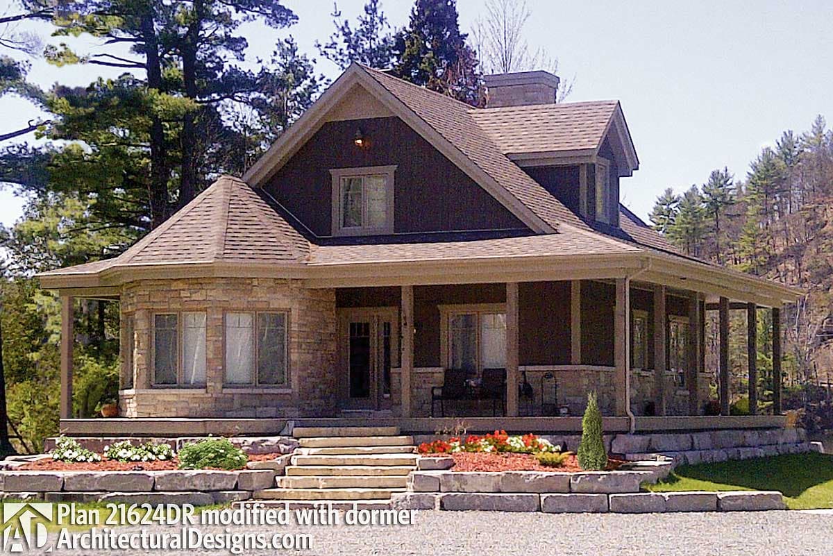House plan exterior: Two-story home with wrap-around porch, stone accent turret, and gabled dormer.