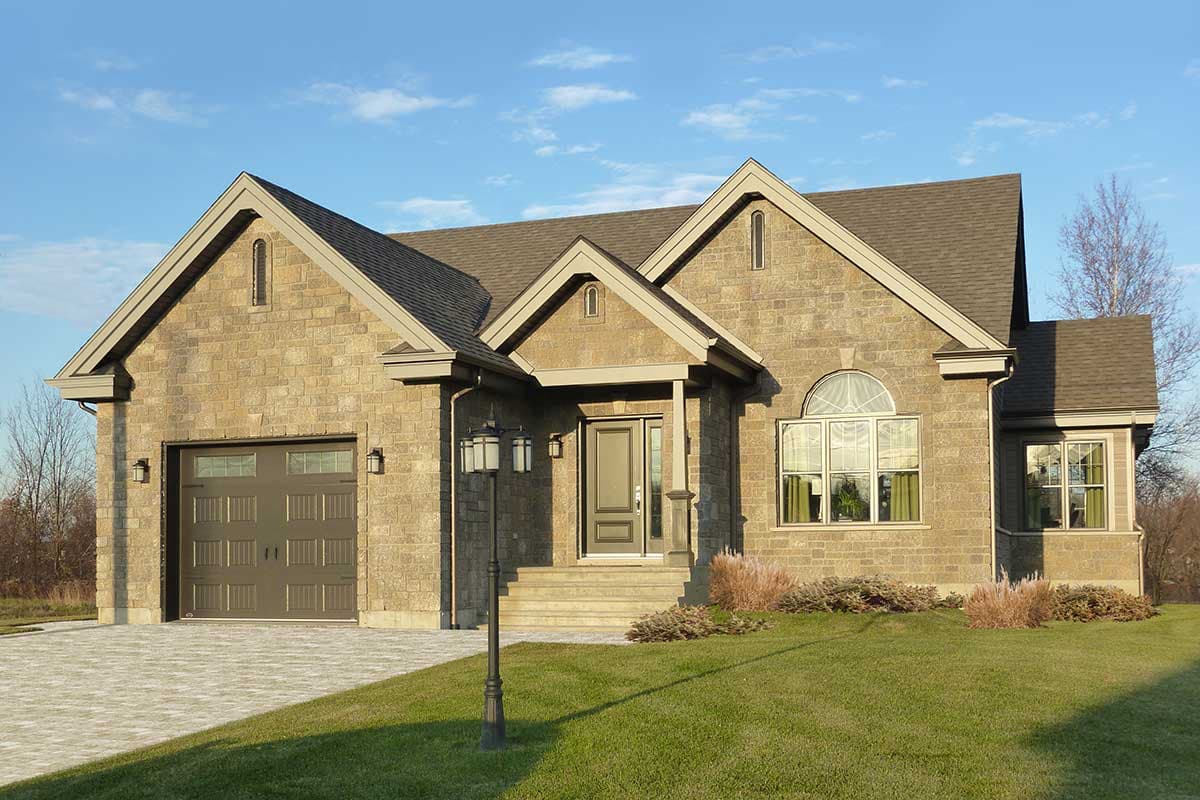 House plan exterior: One-story home with stone facade, attached garage, covered entry, and gabled rooflines.