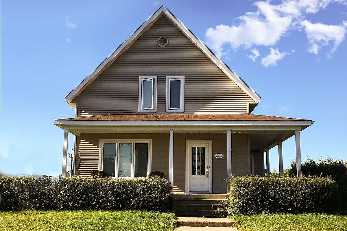 House plan exterior: Two-story home with a gable roof, covered porch, and double-hung windows.