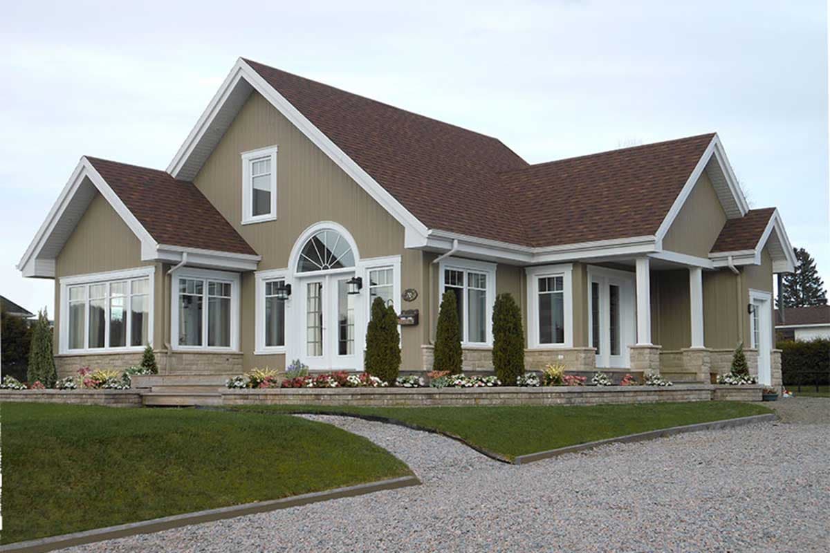 House plan exterior of a one-story home with gabled dormers, arched entryway, and covered porch.