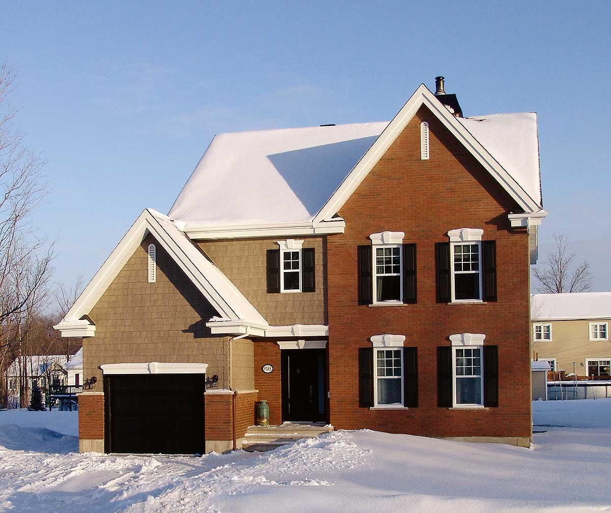 Two-story house plan exterior with brick and shingle siding, prominent gables, attached garage, and a covered entryway.