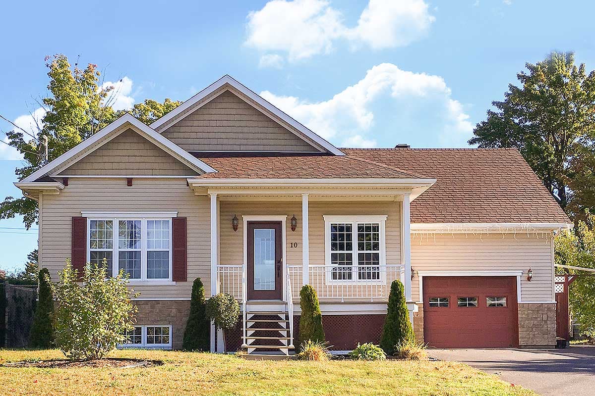 House plan exterior. Ranch style with a front porch, multiple gables, and a garage. Features include a brick facade, and a brown roof.