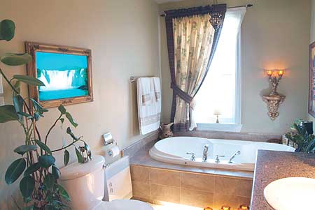 Bathroom with soaking tub, toilet, vanity, and decorative artwork.