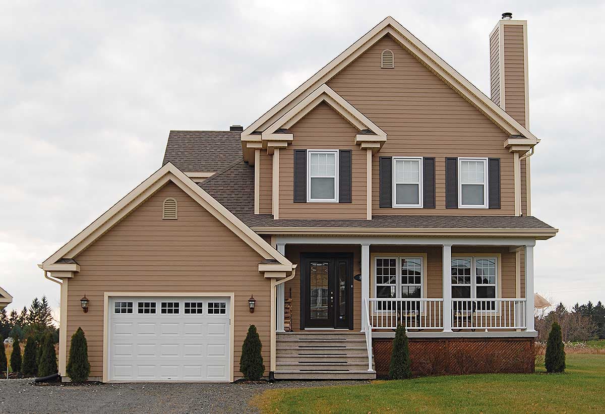 House plan exterior: Two-story home with a gabled front, covered porch with white railings, and an attached garage with a square windowed door.