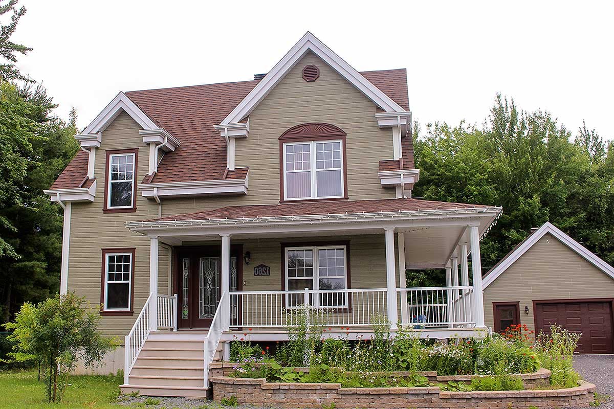 Two-story house plan exterior with front porch, gables, dormers, and attached garage.