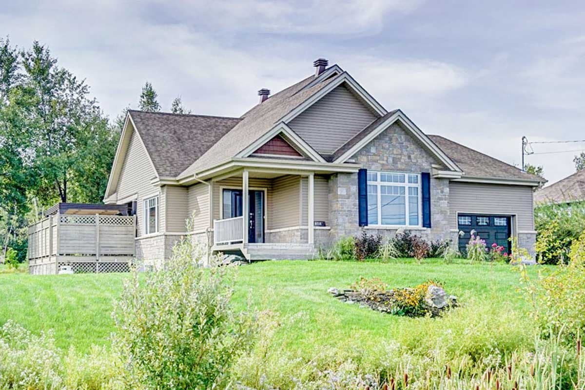 House plan exterior: One-story home with a covered front porch, stone and siding facade, prominent gables, and an attached garage.