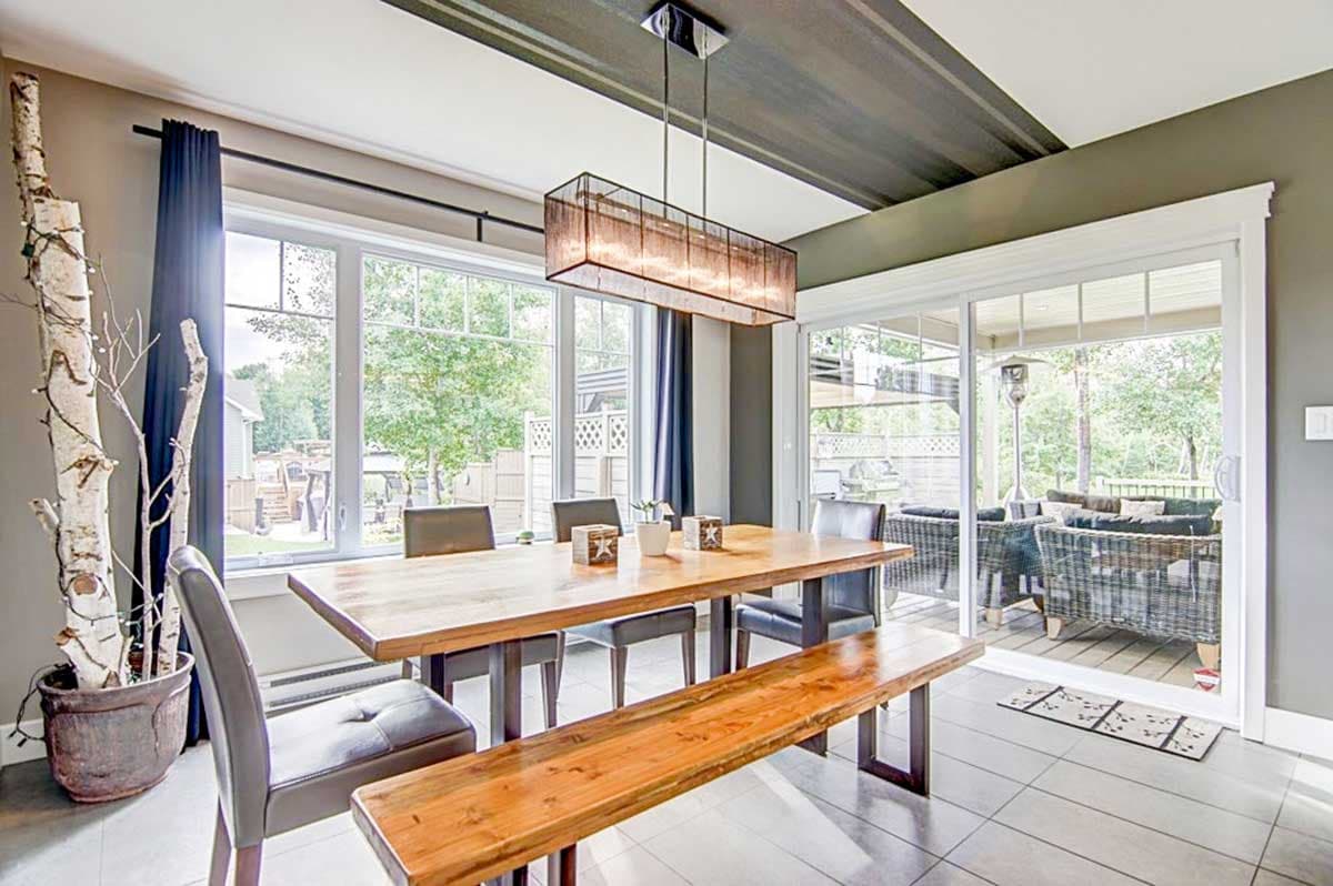 Dining room with large windows, sliding glass door to patio, and modern pendant light.