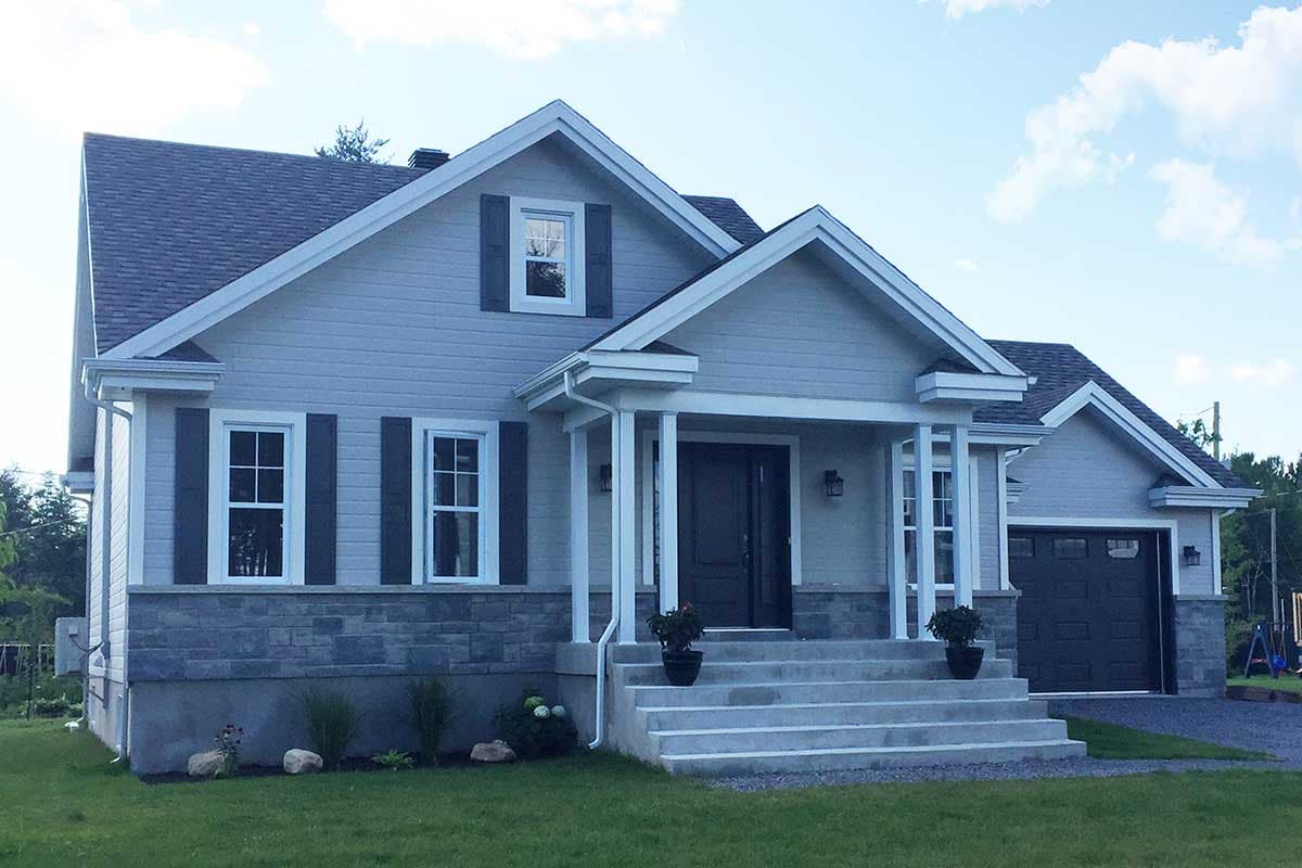 House plan exterior: Two-story home with gable roof, front-facing garage, covered porch with columns, and stone facade base.