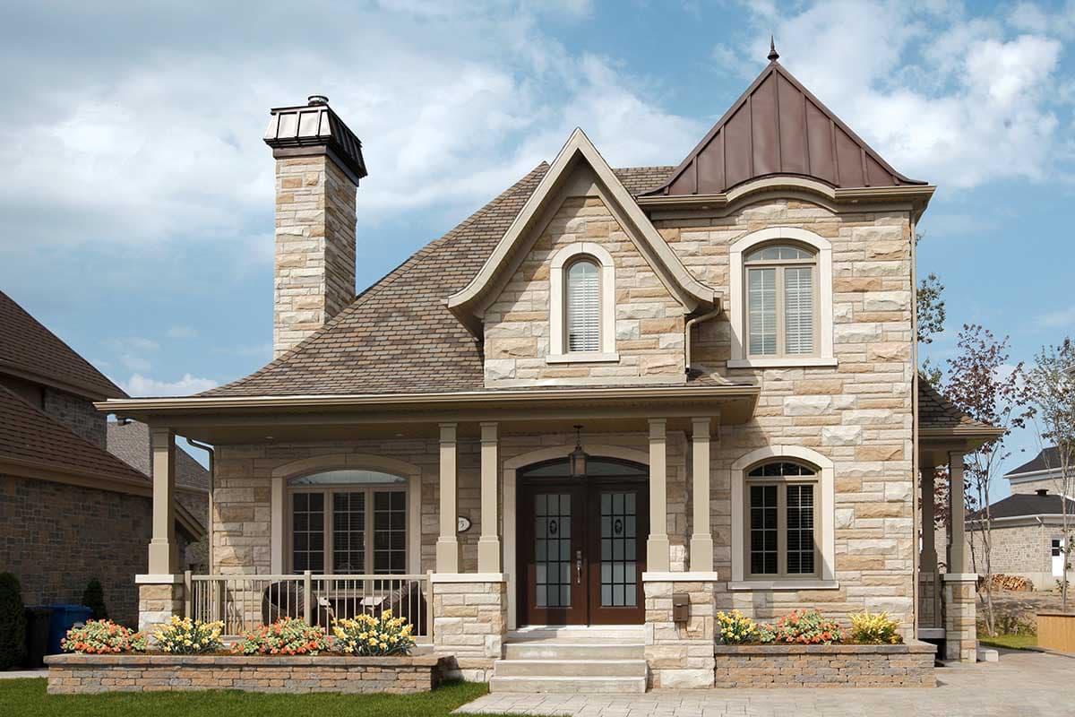 House plan exterior with stone facade, covered porch with columns, arched windows, and a prominent stone chimney.