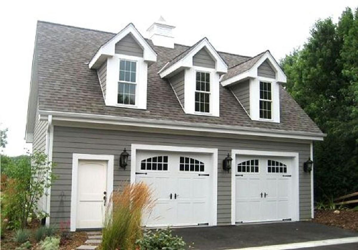 House plan exterior with a pitched roof, three dormers, and a two-car garage.