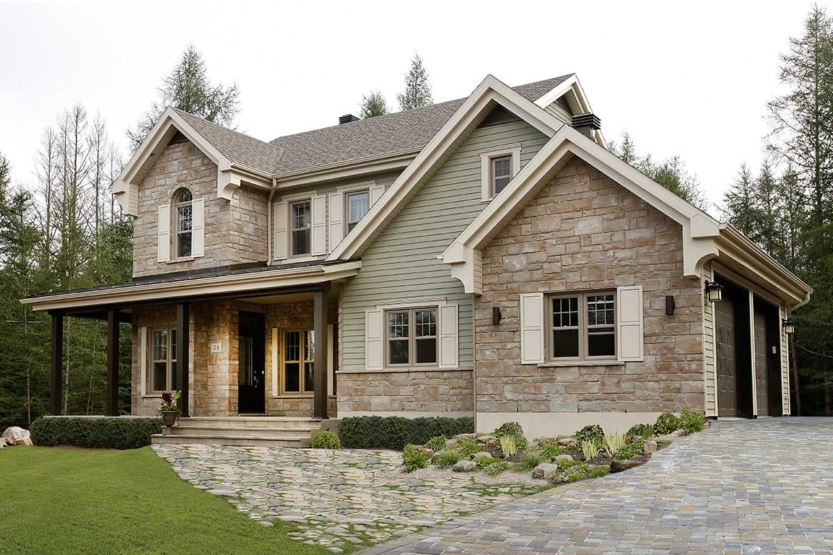 House plan exterior: Two-story home with stone and siding, covered porch, multiple gables, and attached two-car garage.