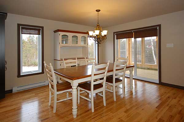 Dining room with wooden table and chairs, hutch, and sliding glass doors to deck.