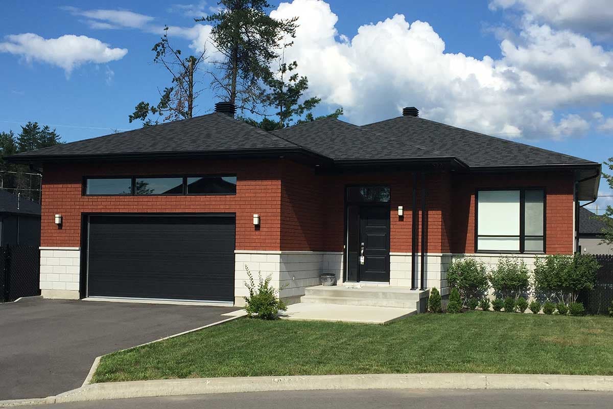Modern ranch house plan exterior with red brick facade, large garage, entry porch, and dark gable rooflines.