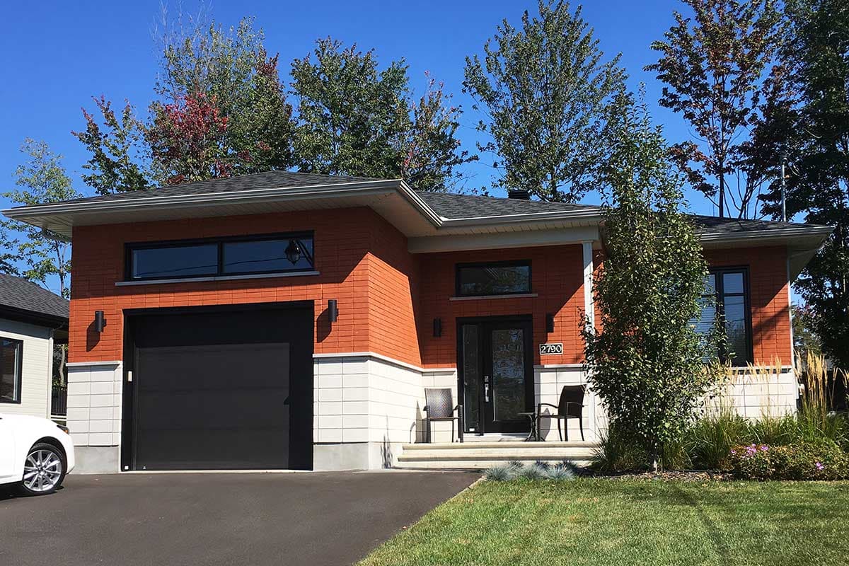 House plan exterior: One-story modern home with brick facade, attached garage, and horizontal windows.