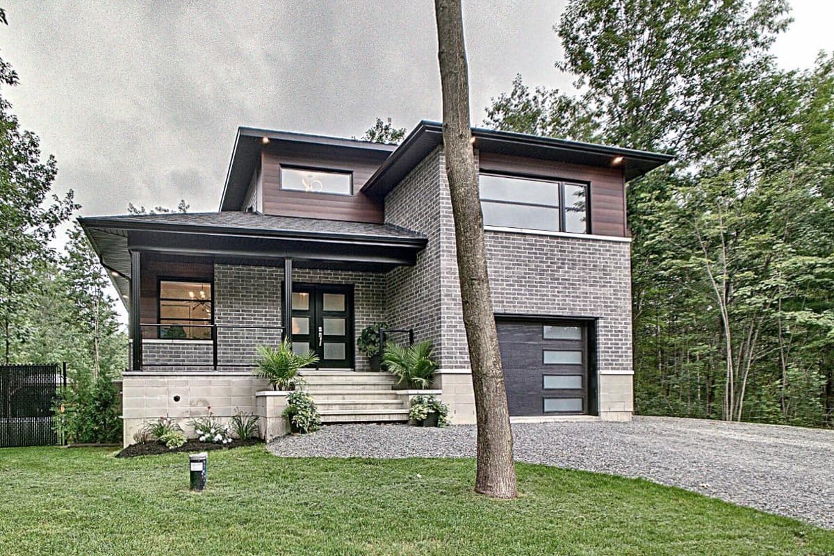Modern house plan exterior with brick facade, gabled roof, covered porch, and attached garage with horizontal windows.