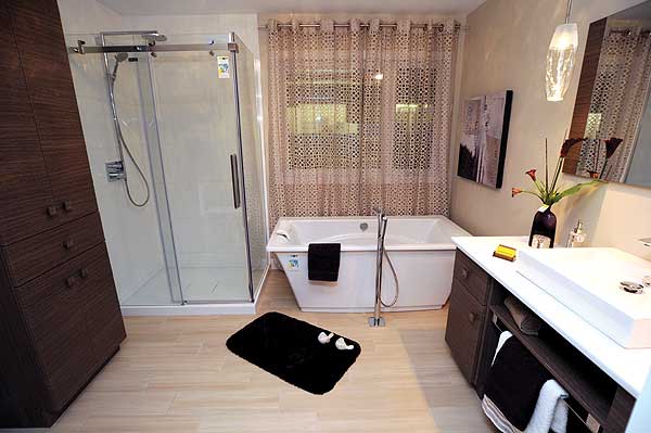 Bathroom with glass-enclosed shower, freestanding tub, vanity with vessel sink, and tall linen cabinet.