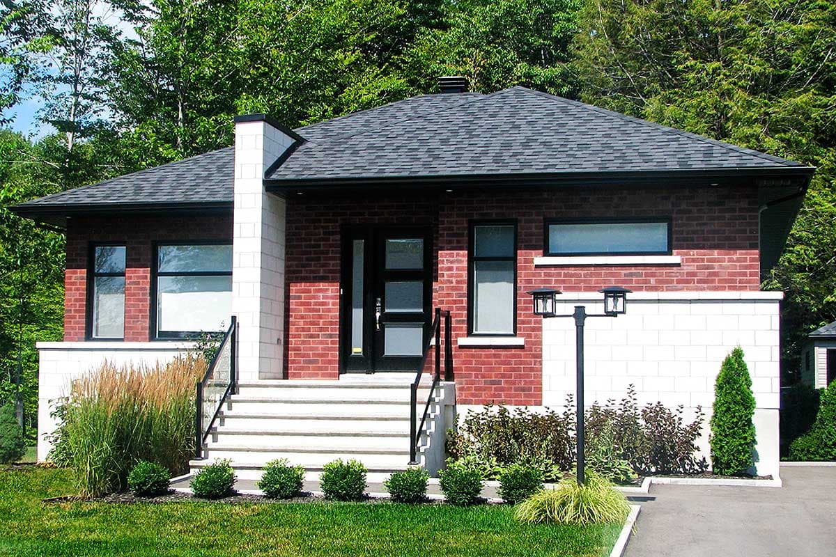House plan exterior: One-story home with red brick facade, white brick accents, wide steps, modern entry door, and hip roof.