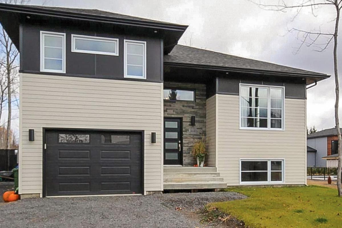 Modern house plan exterior with two stories, a single-car garage, horizontal siding, and a prominent gabled roofline.