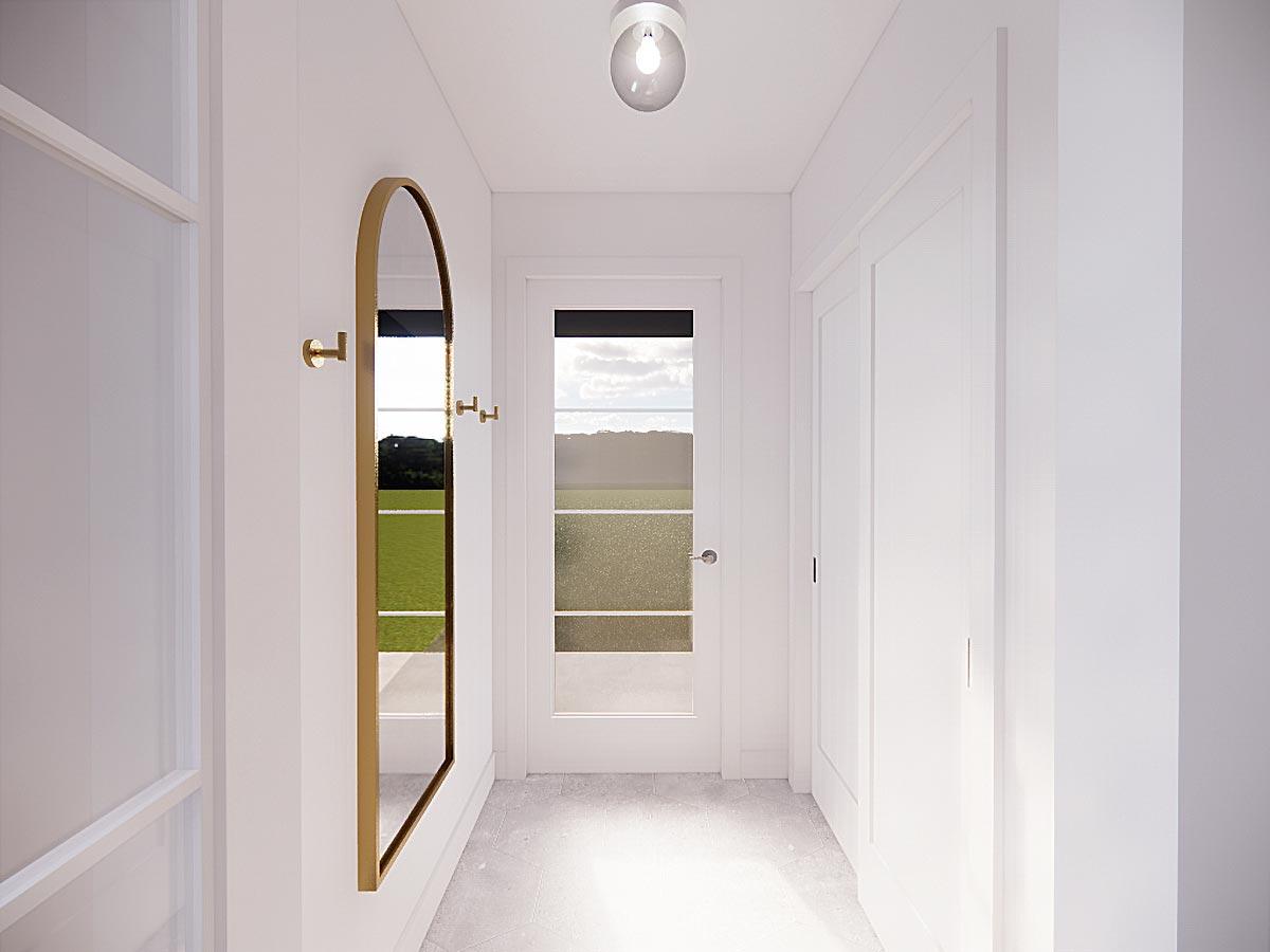 Interior hallway with tall arched mirror, two coat hooks, and a glass-paneled door revealing a landscape view.