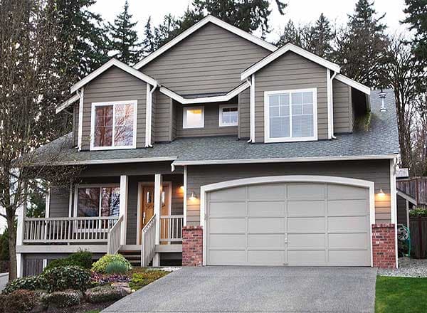 House plan exterior, two stories, gable dormers, wraparound porch, and a two-car garage with arched door.