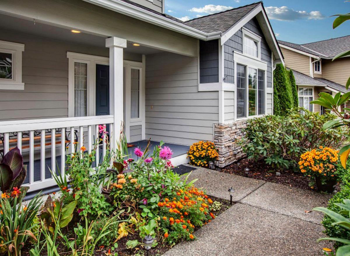 House plan exterior: Modern Farmhouse style with covered porch, stone accents, gables, and lap siding.