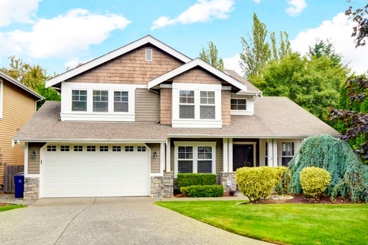 House plan exterior. Two-story home with Craftsman-style elements, front-facing garage, gabled roof, and dormers.