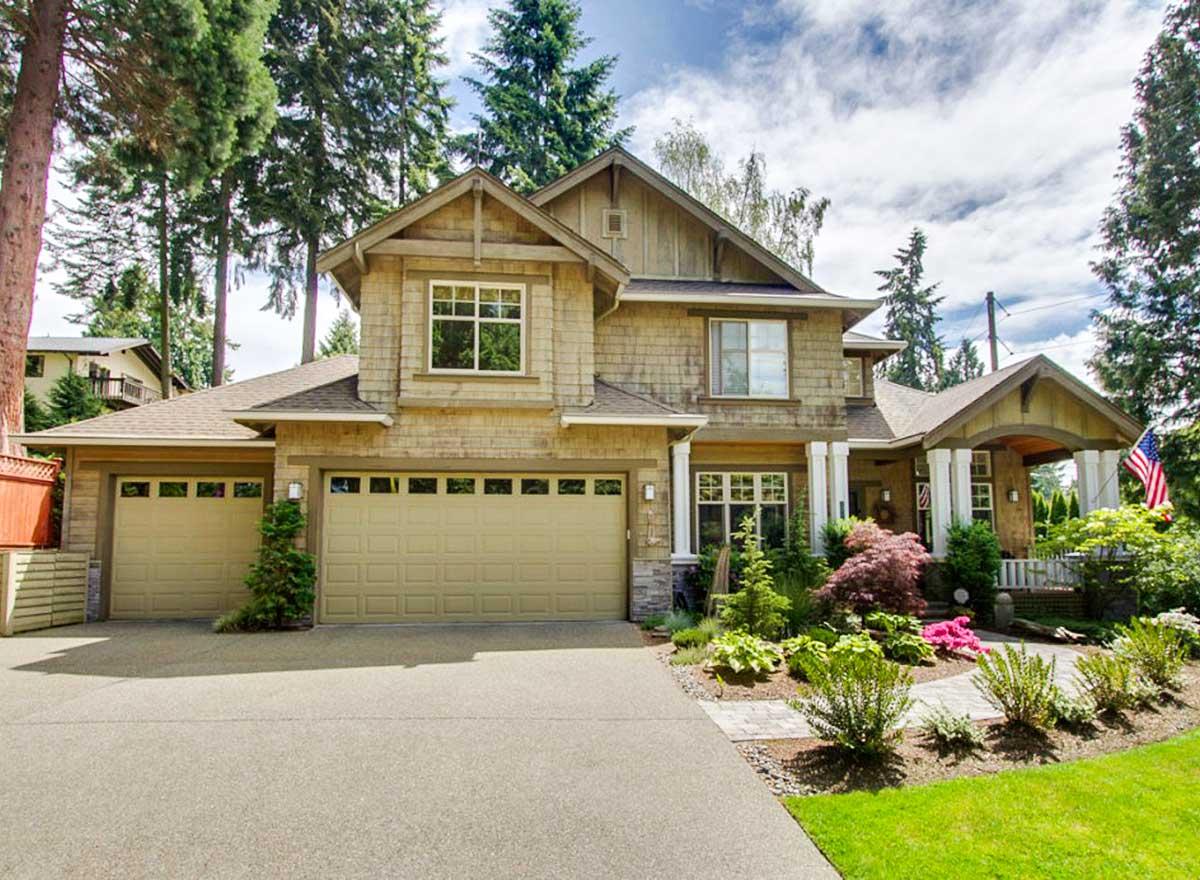 House plan exterior. Two-story Craftsman home with a gabled roof, dormers, a front porch, and an attached two-car garage.