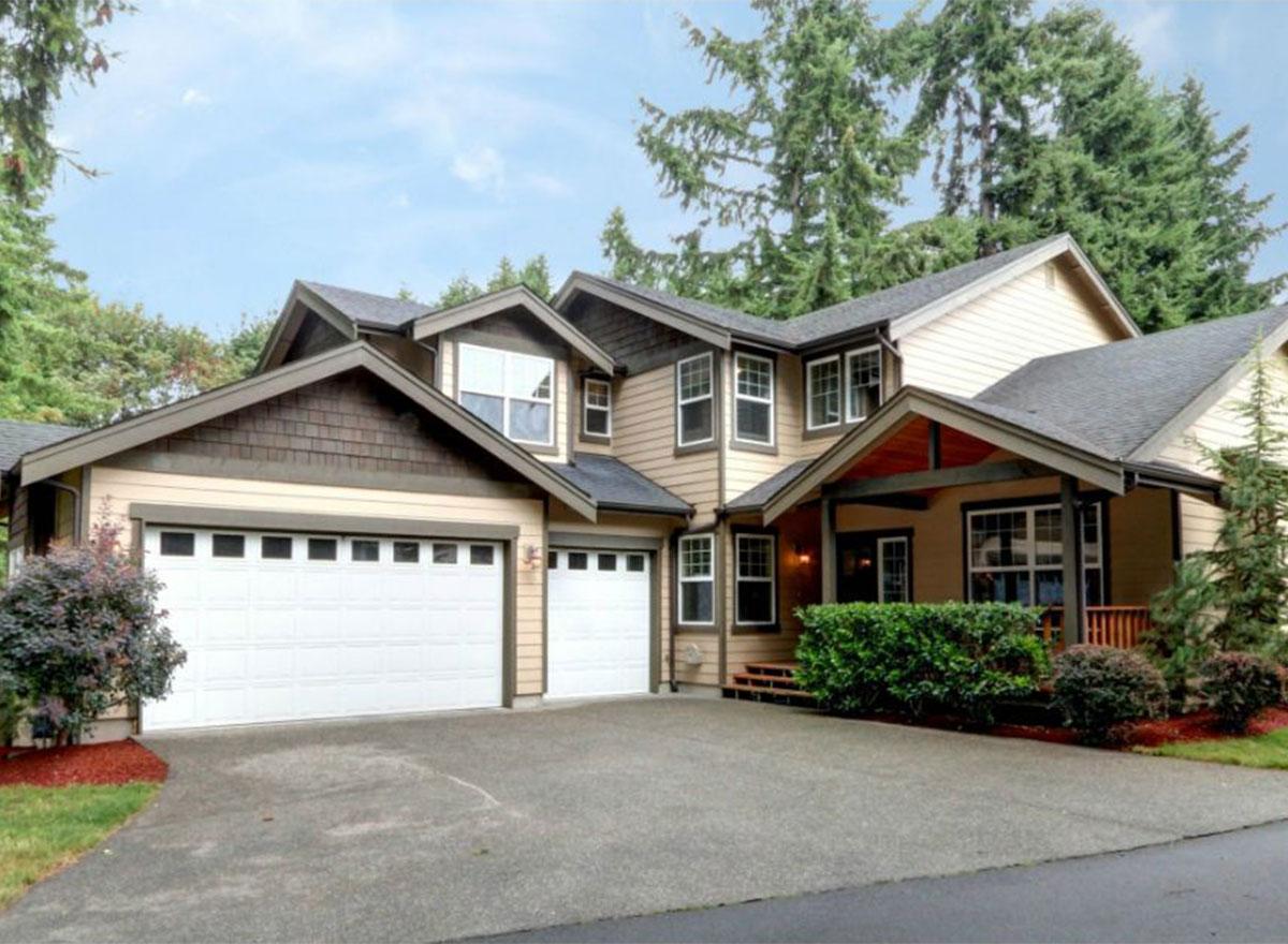 Two-story house plan exterior with a three-car garage, gabled dormers, and a covered entry porch.