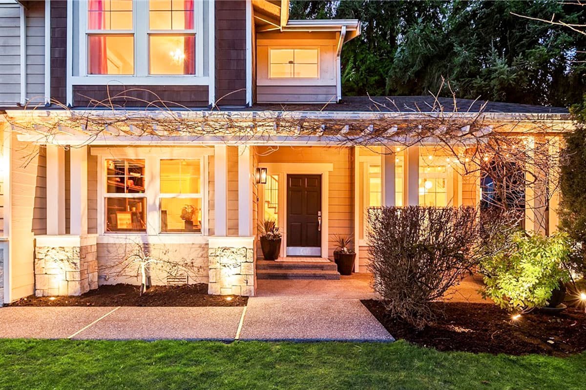 House plan exterior shows a two-story home with a covered porch, multiple gables, and stone accents on the lower facade.