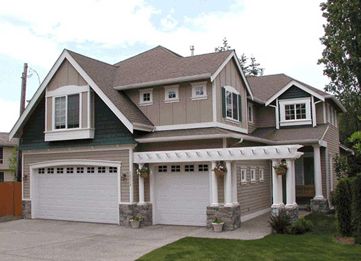 House plan exterior: Two-story home with a three-car garage, prominent gables, dormers, and a covered pergola.