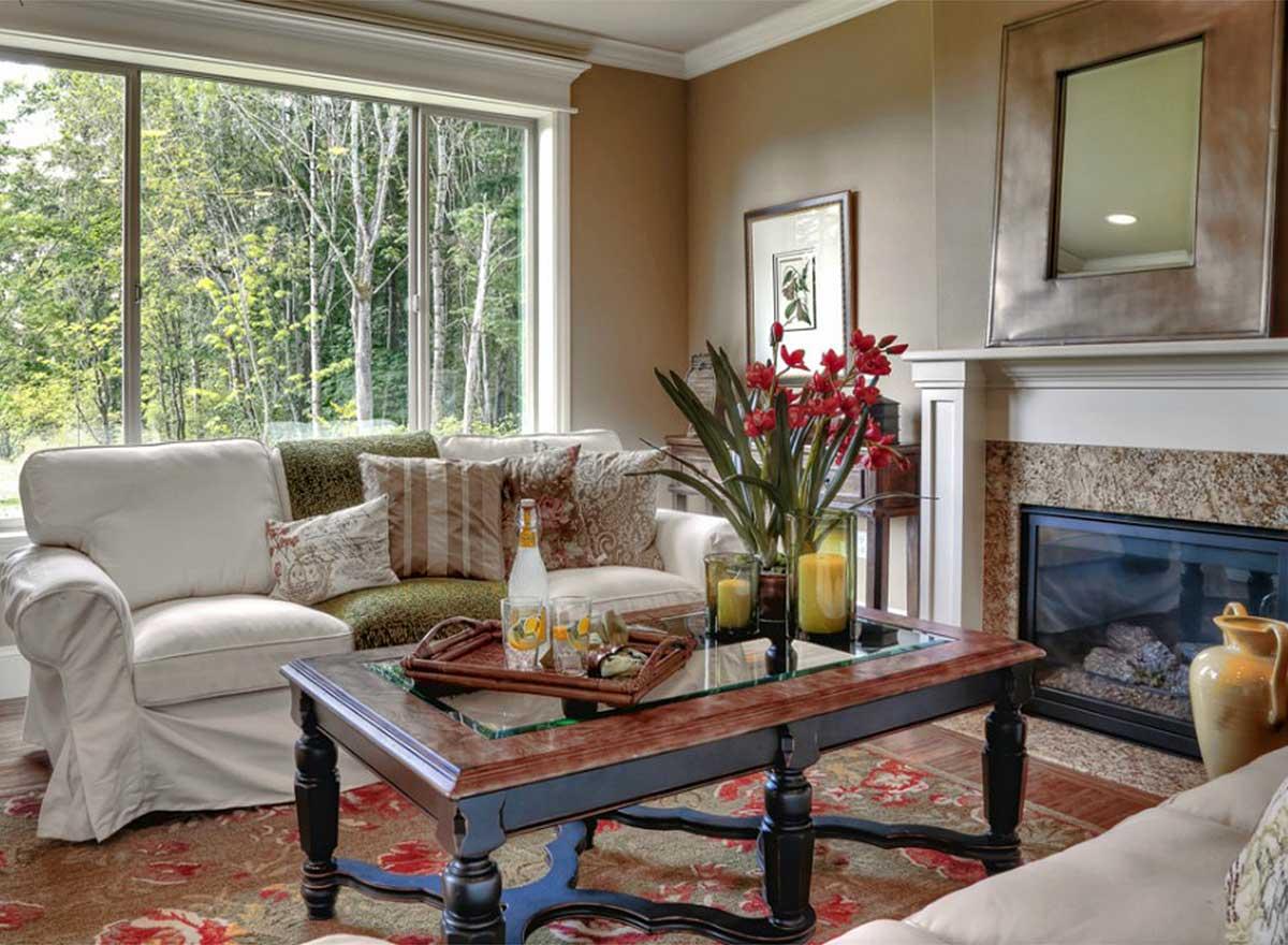 Living room with large windows, fireplace, and decorative coffee table.