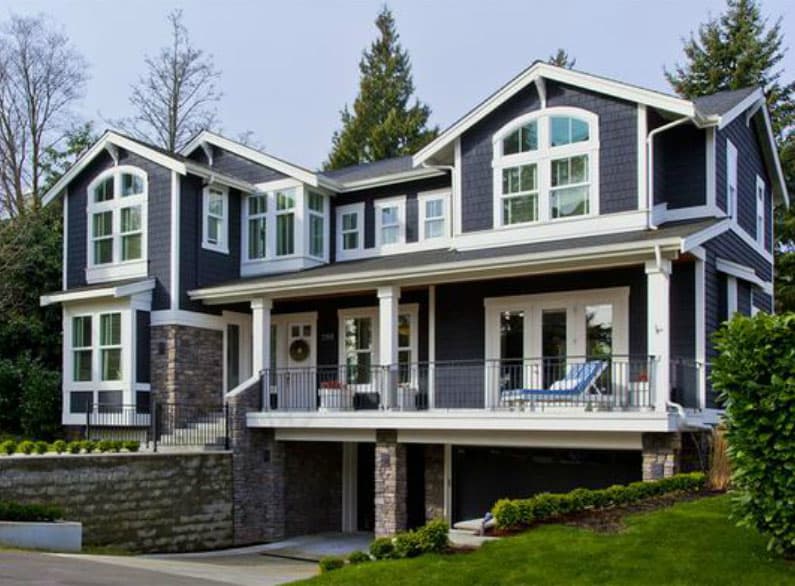 House plan exterior. Two-story Craftsman home with a covered porch, multiple gables, and arched windows. Garage is integrated into the structure.