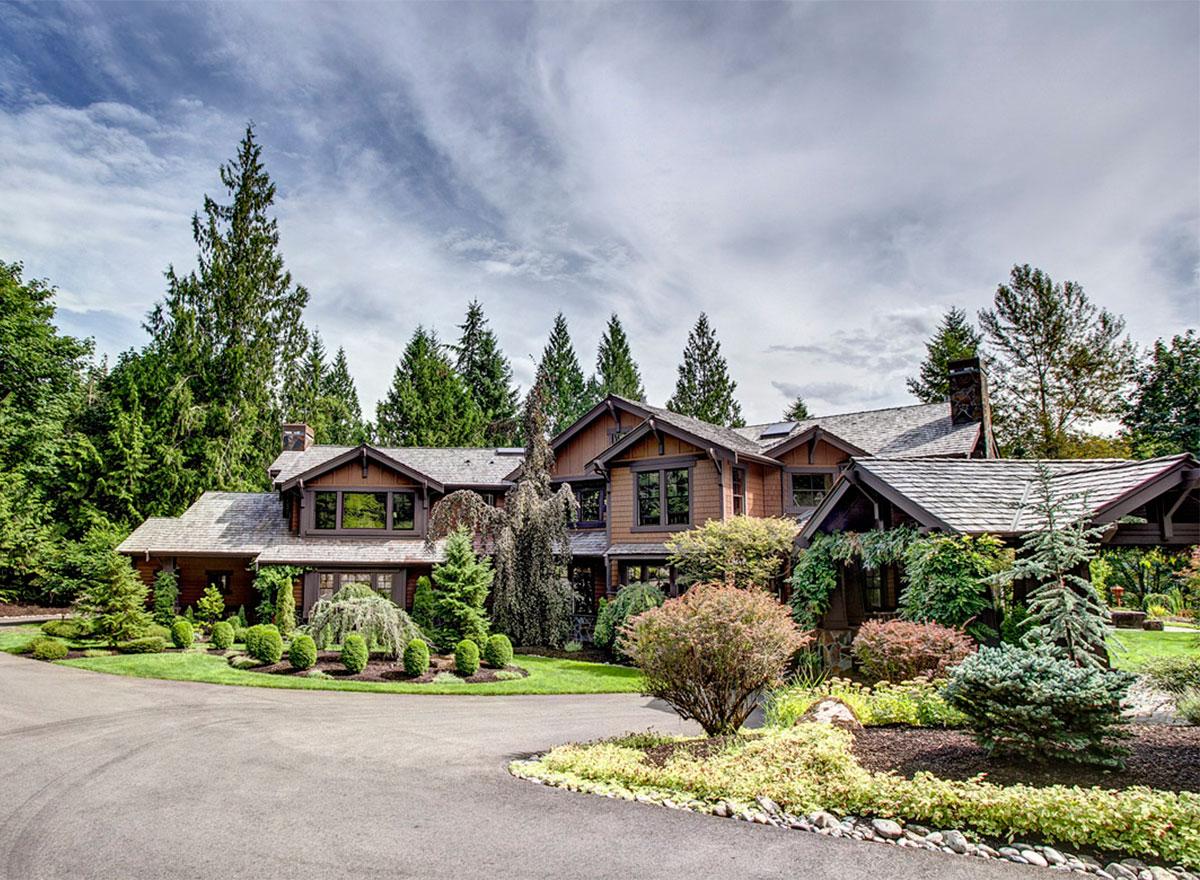 Craftsman style house plan exterior with multiple gables, wood siding, stone accents, and a covered entryway.