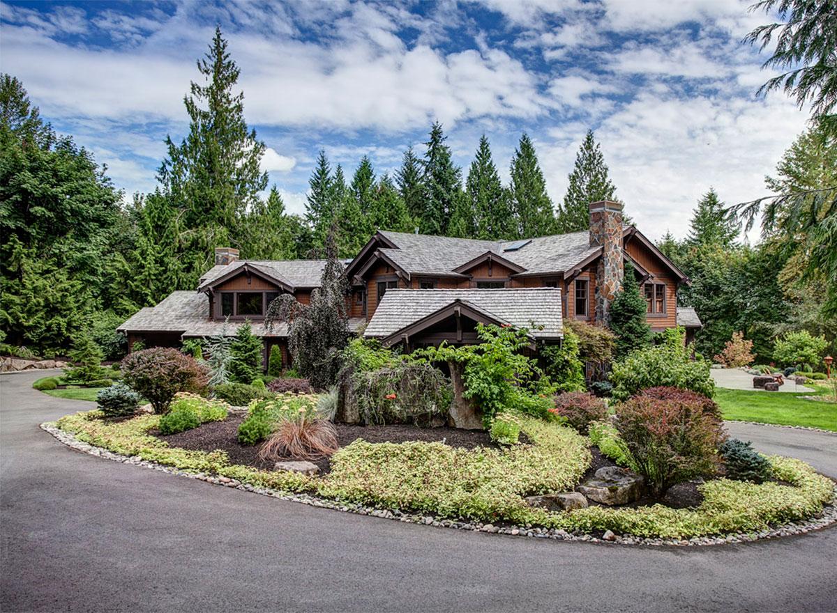 House plan exterior: Timber-framed home with multiple gables, stone chimney, and shingled roof.