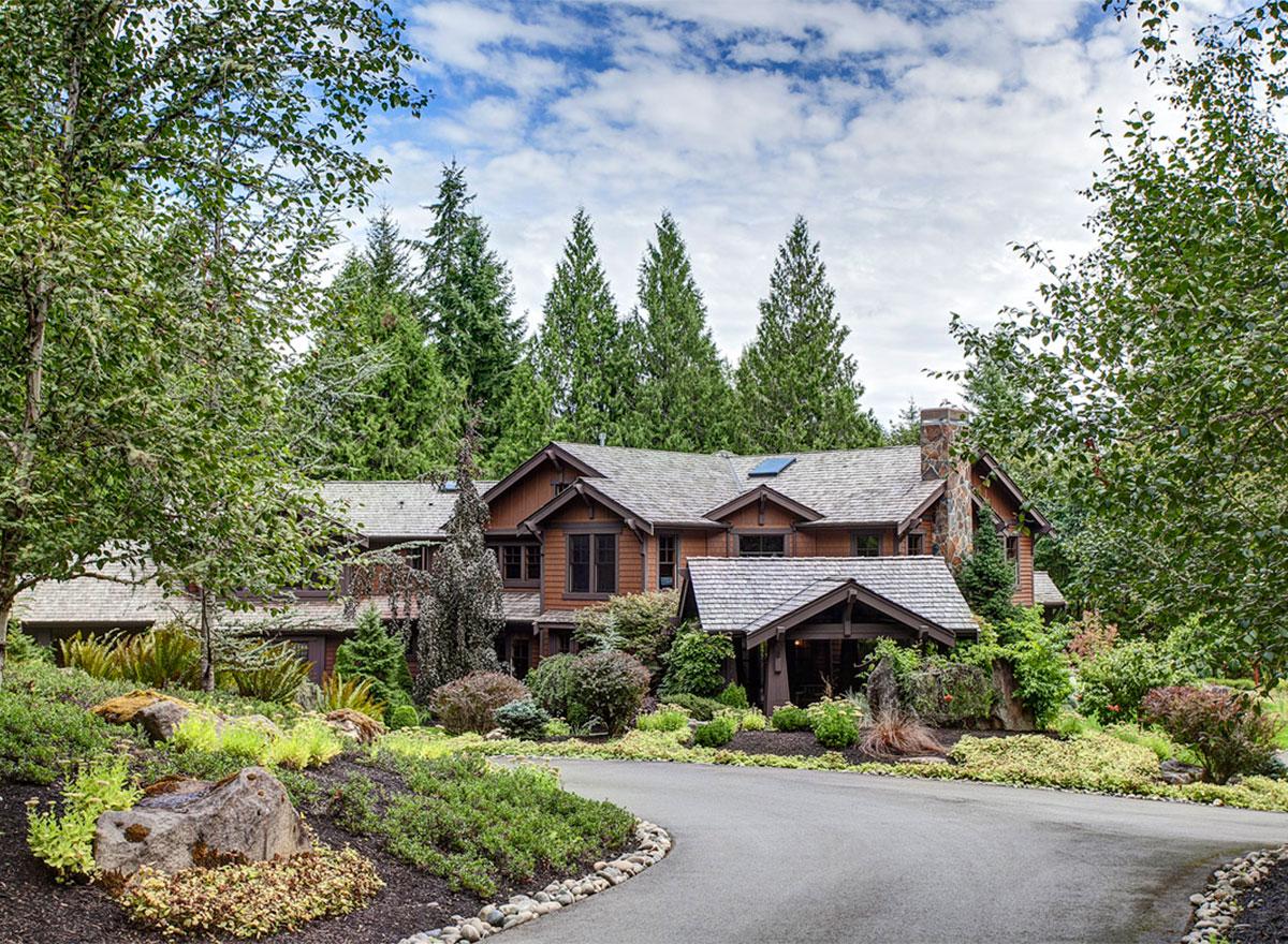 Craftsman style house plan exterior with multiple gables, stone chimney, and covered entry.